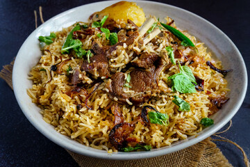 A flavorful serving of mutton pulao or goat meat pilaf, cooked with fragrant basmati rice, ghee, caramelized onions, and aromatic spices. This Bengali-style rice and meat dish blends rich flavors with