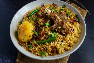 A flavorful serving of mutton pulao or goat meat pilaf, cooked with fragrant basmati rice, ghee, caramelized onions, and aromatic spices. This Bengali-style rice and meat dish blends rich flavors with