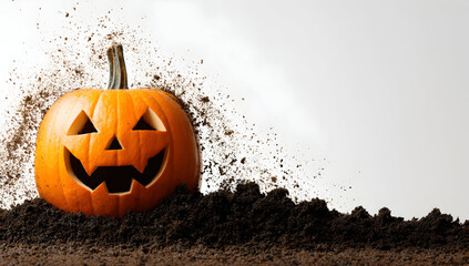 A jack o lantern on a pile of dirt with dirt particles flying around it on a white background