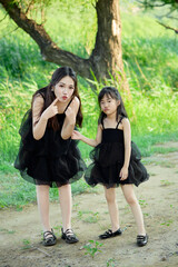 Obraz premium Asian mother and daughter traveling and having fun in outdoor park in summer