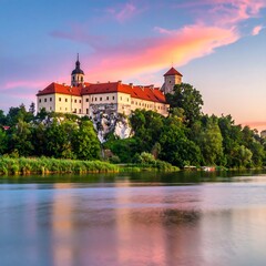 Naklejka premium A majestic castle sits atop a rocky cliff overlooking a tranquil lake