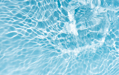 Blue water with ripples on the surface. Defocus blurred transparent blue colored clear calm water surface texture with splashes and bubbles. Water waves with shining pattern texture background.