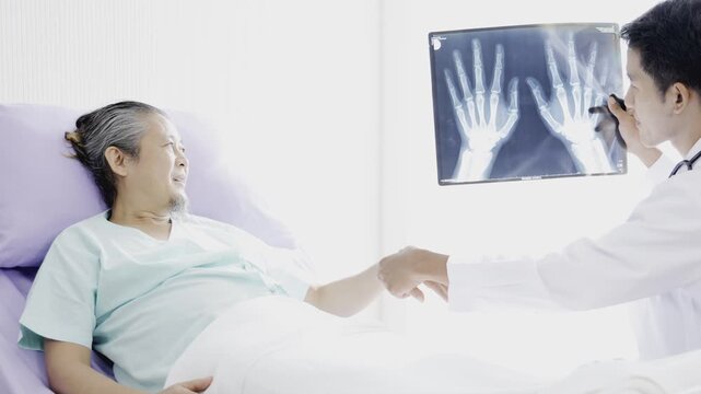 The doctor came to give advice on bone treatment. Doctor explains to a male patient with a broken hand the result of an x-ray.