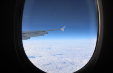 Airplane flying above clouds at 40000 feet view from window