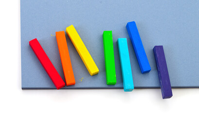 Colorful pastel chalk sticks on blue paper background