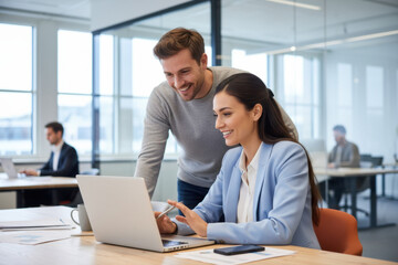 Fototapeta premium A man and a woman looking at a laptop screen together