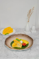 Exotic Mango Dessert: The artful arrangement of ripe mango slices and tropical elements on an earthy plate creates a sensory experience.