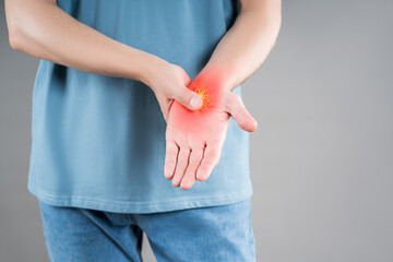 Hand pain, carpal tunnel syndrome, gray background, painful area highlighted in red