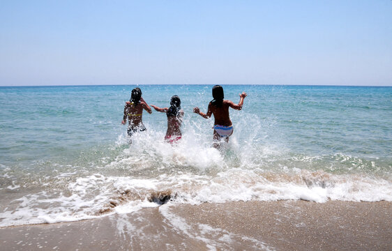 Children Splashing in Sunlit Waves