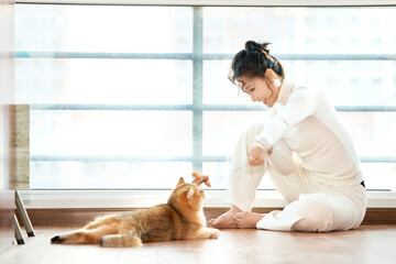 Asian beauty playing with cat at home on holiday
