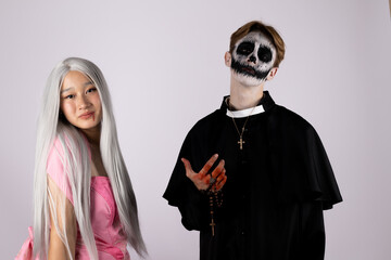 Woman in pink dress dances gracefully as man in robe plays violin passionately