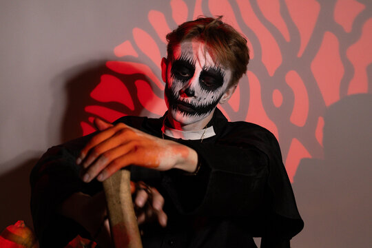Man with skeleton face holding a knife,intense expression,Halloween theme