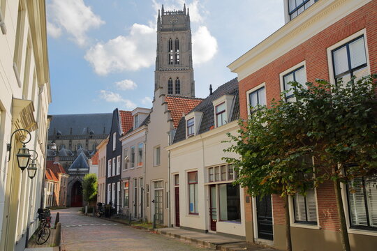 Traditional historic and colorful medieval houses located along Kerkstraat street in the old picturesque fortified town of Zaltbommel, Gelderland, Netherlands, with Sint Maartenskerk
