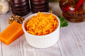 Yellow shredded cheddar cheese in the bowl