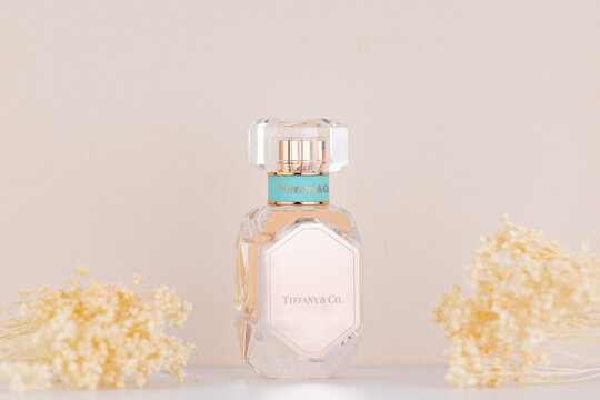 Studio shot of Tiffany & Co. Rose Gold Eau de Parfum perfume bottle with elegant crystal design, photographed with soft floral accents for illustrative editorial use.
