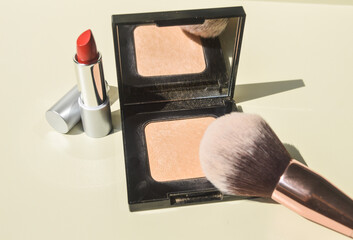 Make-up products: woman using make-up. Cosmetics, beauty products, compact powder, powder brush,...