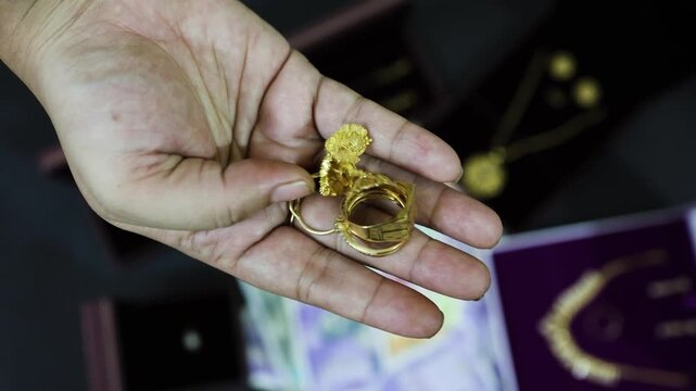 Adult Hand Holding depicting Indian Cultural Gift Of Gold Ring And Wealth