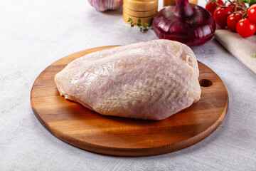 Raw chicken breast with bone and skin