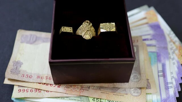 Elegant ring collection arranged in box over currency notes symbolizing prosperity