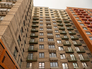Close-up architectural detail of a modern building's corner, focusing on window frames and brick...
