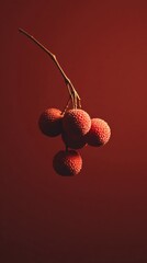 Colorful lychee fruits hanging against a deep red background in a simple and elegant display