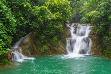 Fototapeta premium Waterfalls and streams among green mountains and clear waters in Guizhou Xiaoqikong Scenic Area