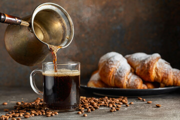 Croissants and black coffee on a kitchen table.