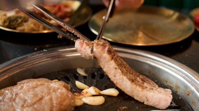 Cutting Grilled Pork Belly on Korean Barbecue Grill Table