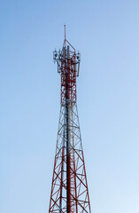 Telecommunication tower with antennas under blue sky