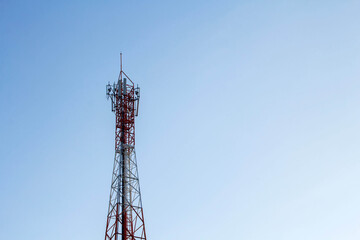 Telecommunication tower with antennas under blue sky