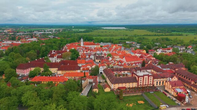 aerial drone shot captures the picturesque medieval town of Třeboň Wittingau in the South Bohemian Region of the Czech Republic, showcasing its historic architecture, vibrant orange rooftops, the maje