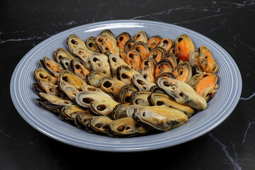 Steamed fresh peeled mussel serving on the plate. Famous seafood on ice menu in restaurant. 