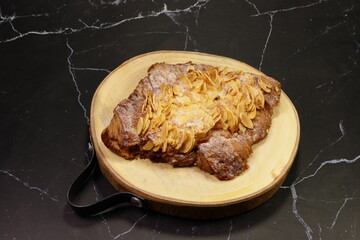 Classic baked croissant topping with cheese and sliced almond serving on the wooden plate. Famous starter and appetizer menu in coffee shop.