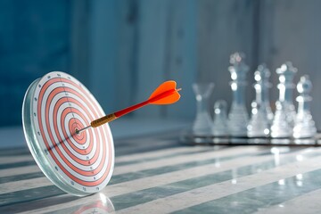 Dart hitting bullseye on target with blurred chess pieces in background