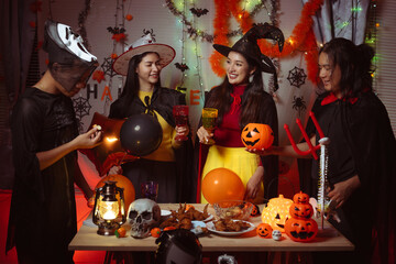 Asian man and woman celebrating Halloween, pumpkins at night, Halloween banner background for holiday activities.