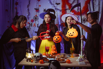 Asian man and woman celebrating Halloween, pumpkins at night, Halloween banner background for holiday activities.