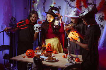 Asian man and woman celebrating Halloween, pumpkins at night, Halloween banner background for holiday activities.
