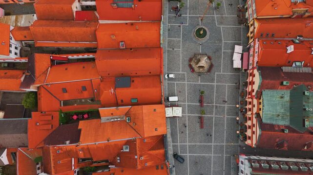 An aerial top down view captures the charming red tiled rooftops and the central town square of the historic town of Trebon in the South Bohemian Region of the Czech Republic, showcasing its unique ar