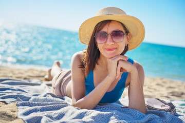 Portrait of woman relaxing on sand on tropical bach.