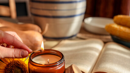Cozy autumn scene with candle, book, and corn