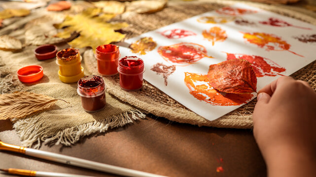 Autumn leaf art project with paint and brushes