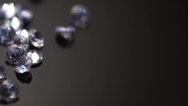 Diamonds, gems, crystals rotating on black background, beautiful shining brilliants sparkling with colorful caustics, rainbow lights. Moissanite. Zirconia. Diamonds sparkle on black. 