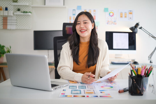 Professional female designer developing website layout and user experience concepts, analyzing color palettes and prototypes. - Powered by Adobe