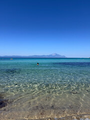 Clear turquoise sea with view of Mount Athos on the horizon, Greece
