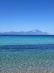 Clear turquoise sea with view of Mount Athos on the horizon, Greece