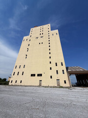 Abandoned industrial building under blue sky in rural landscape
