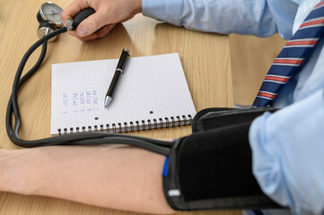 Measuring blood pressure, the patient measures his pulse and blood pressure with a blood pressure...