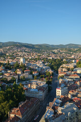 Obraz premium A view of a Sarajevo city with buildings trees and hills in the background under a blue sky