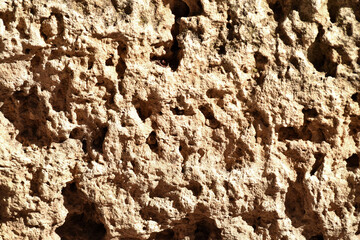 Mud wall texture closeup. Detailed texture of rough mud and clay wall surface in warm light.