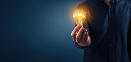 The Light Bulb Symbolizing Creative Idea and Innovation Held in a Human Hand